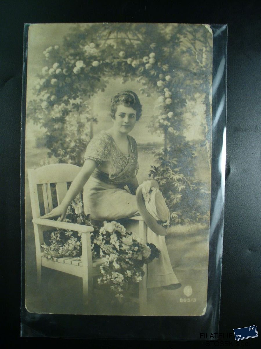 Pohlednice - Mladá žena na lavičce s kyticí
